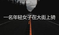 一名年輕女子在大街上騎著青桔共享電單車原地打轉燒胎