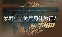 暴雨中，他用身體為行人豎起安全警示牌……